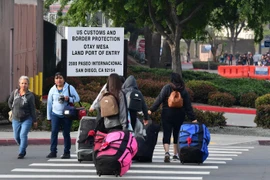 Người di cư di chuyển qua cửa khẩu Otay Mesa ở biên giới Mexico-Mỹ để sang San Diego, bang California (Mỹ) ngày 8/6/2019. (Ảnh: AFP/TTXVN)