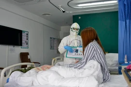 Nhân viên y tế chăm sóc bệnh nhân nhiễm COVID-19 tại bệnh viện ở Bắc Kinh, Trung Quốc, ngày 30/3 vừa qua. (Ảnh: THX/TTXVN)