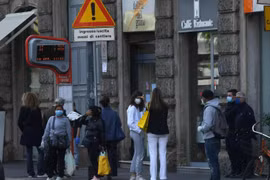 Người dân đợi xe buýt tại bến xe ở Milan, Italy ngày 18/4/2020 trong bối cảnh dịch COVID-19 đang hoành hành. Ảnh: THX/TTXVN