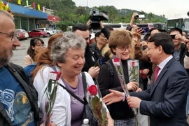 Bí thư Tỉnh ủy Nguyễn Xuân Ký tặng hoa và mừng tuổi cho du khách quốc tế đến Quảng Ninh đầu Xuân Canh Tý. (Ảnh: Đức Hiếu/TTXVN)