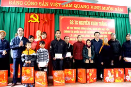 Ông Nguyễn Xuân Thắng trao quà cho các hộ nghèo, gia đình chính sách xã Tân Tiến. (Ảnh: Quang Cường/TTXVN)