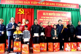 Ông Nguyễn Xuân Thắng trao quà cho các hộ nghèo, gia đình chính sách xã Tân Tiến. (Ảnh: Quang Cường/TTXVN)