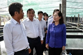 Bà Nguyễn Thị Lệ, Chủ tịch HĐND Thành phố Hồ Chí Minh nghe ông Nguyễn Văn Thủy, chủ trại cá cảnh ở Tổ 7, ấp Cây Trôm, xã Phước Hiệp, huyện Củ Chi báo cáo về tình hình sản xuất, kinh doanh. (Ảnh: Xuân Khu/TTXVN)