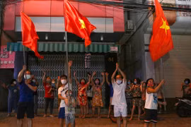Người dân ở trên tuyến đường Nguyễn Thị Minh Khai vui mừng sau khi hoàn thành cách ly 14 ngày trong khu vực phong tỏa. (Ảnh: Trần Lê Lâm/TTXVN)