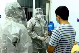 Nhân viên y tế thực hiện các biện pháp nghiệp vụ với bệnh nhân nghi mắc nCoV. (Ảnh: Thành Chung/TTXVN)