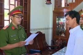 Đọc quyết định bắt tạm giam đối với Trần Hải Âu, cán bộ địa chính phường Hòa Hiệp Trung. (Ảnh: TTXVN phát)