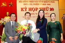 Bí thư Tỉnh ủy Quảng Ngãi Bùi Thị Quỳnh Vân tặng hoa chúc mừng ông Đặng Văn Minh. (Ảnh: Sỹ Thắng/TTXVN)