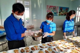 Các đoàn viên thanh niên chuẩn bị cơm cho công dân tại khu các ly tập trung. (Ảnh: Võ Dung/TTXVN)