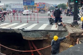 Phần mặt đường bị sụt lún rộng hơn 3m, sâu khoảng 2m. (Ảnh: Tiến Lực/TTXVN)
