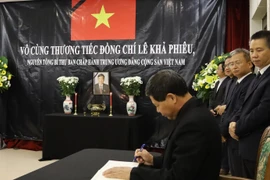 Đại sứ Lê Quý Quỳnh ghi sổ tang tại lễ viếng nguyên Tổng Bí thư Lê Khả Phiêu. (Ảnh: TTXVN/phát)