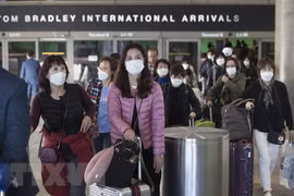 Hành khách đeo khẩu trang đề phòng lây nhiễm COVID-19 tại sân bay quốc tế Los Angeles, bang California, Mỹ. (Ảnh: AFP/TTXVN)