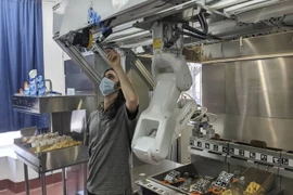 Các robot có thể lật bánh mì kẹp thịt, làm salad và thậm chí nướng bánh mỳ đang có nhu cầu ngày càng tăng khi các nhà bếp đề phòng virus cố gắng tạo khoảng cách giữa công nhân và khách hàng. (Nguồn: AP)