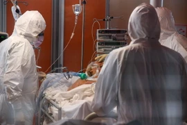 Nhân viên y tế điều trị cho bệnh nhân nhiễm COVID-19 tại bệnh viện. (Ảnh: THX/TTXVN)