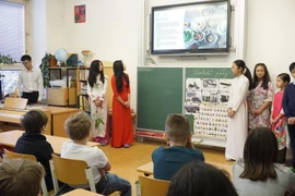 Các em học sinh giới thiệu về truyền thống gia đình Việt Nam. (Ảnh: Hồng Kỳ/TTXVN)