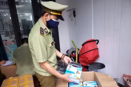 Lực lượng Quản lý thị trường thu giữ nhiều khẩu trang không rõ nguồn gốc, xuất xứ. (Ảnh: Quốc Dũng/TTXVN)