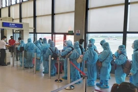 Công dân Việt Nam làm thủ tục lên máy bay để về nước. (Ảnh minh họa: TTXVN phát)