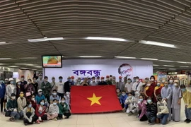 Công dân Việt Nam tại Bangladesh chuẩn bị làm thủ tục lên máy bay về nước. (Ảnh: TTXVN phát)