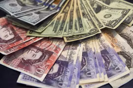 Đồng bảng Anh và đồng USD. (Ảnh: AFP/TTXVN)