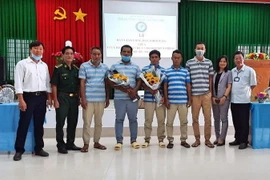 Năm thuyền viên Indonesia cùng đại diện các cơ quan đơn vị tại buổi lễ bàn giao. (Ảnh: TTXVN/phát)