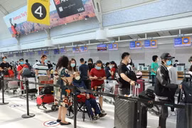 Công dân Việt Nam làm thủ tục lên máy bay về nước tại sân bay thành phố Toronto. (Ảnh: Quang Thịnh/TTXVN)