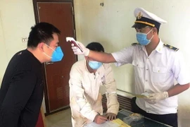 Các thuyền viên trên tàu được đo thân nhiệt, kiểm tra sức khỏe và khai báo y tế phòng tránh dịch bệnh COVID-19. (Ảnh: TTXVN phát)