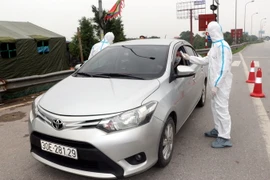 Kiểm tra thân nhiệt các trường hợp. (Ảnh: Văn Đạt/TTXVN)