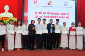 Trao giấy chứng nhận học bổng cho sinh viên. (Ảnh: Tường Vi/TTXVN)