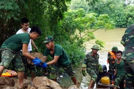 Các lực lượng tiến hành gia cố chân đê và mặt ngoài đê. (Ảnh: Tá Chuyên/TTXVN)