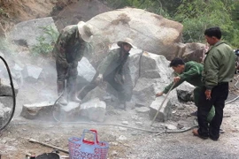 Công nhân phá đá khắc phục sạt lở tại Km36+050, Quốc lộ 27, thuộc địa bàn xã Yang Tao, huyện Lắk. (Ảnh: Phạm Cường/TTXVN)