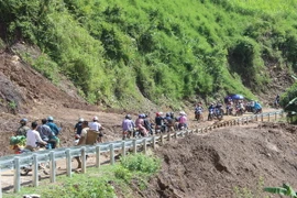 Các đơn vị đang gấp rút thi công, khắc phục những đoạn đường bị ảnh hưởng để có thể thông tuyến vào lúc 21 giờ ngày 12/10. (Ảnh: Nguyễn Cường/TTXVN)