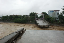 Cầu Thia tại thị xã Nghĩa Lộ bị nước lũ cuốn trôi. (Ảnh: Thế Duyệt/TTXVN)