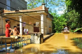 Nước ngập sâu nên người dân tại thôn Kiến Phong, xã Gia Tường, huyện Nho Quan, Ninh Bình phải di chuyển bằng thuyền. (Ảnh: Minh Đức/TTXVN)