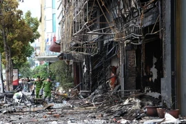 Cảnh sát khám nghiệm hiện trường vụ cháy. (Ảnh: Doãn Tấn/TTXVN)