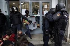 Cảnh sát Tây Ban nha tịch thu các hòm phiếu tại một điểm bỏ phiếu ở Barcelona ngày 1/10. (Nguồn: AFP/TTXVN)