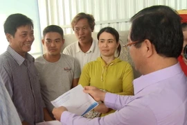 Bí thư Tỉnh ủy Quảng Ngãi Lê Viết Chữ trao tiền hỗ trợ cho ngư dân. (Ảnh: Phước Ngọc/TTXVN)