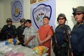 Cảnh sát Campuchia đưa những tên tội phạm cùng số tang vật ra cuộc họp báo ở Phnom Penh. (Nguồn: AFP/TTXVN) 