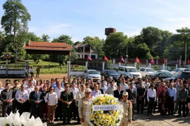 Các đại biểu cùng đông đảo kiều bào dâng hương tưởng niệm tại nghĩa trang liệt sỹ Liên quân Lào-Việt. (Ảnh: Phạm Kiên/Vietnam+)