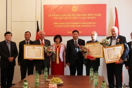 Đại sứ Đoàn Xuân Hưng trao Huân trương cho một số tổ chức và bạn bè Đức. (Ảnh: Mạnh Hùng/Vietnam+) 
