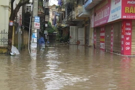 Nhiều tuyến phố ngập nặng, người và các phương tiện không thể lưu thông. (Ảnh: Mạnh Minh/TTXVN) 