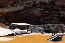 Xe máy xúc bị dòng nước cuốn trôi lật chổng bánh tại hiện trường sự cố vỡ đường ống dẫn dòng Công trình thủy điện Sông Bung 2. (Ảnh: Trần Lê Lâm/TTXVN)