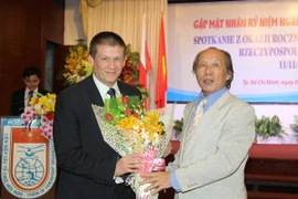 Chủ tịch Hội Hữu nghị Việt Nam-Ba Lan TP.HCM Nguyễn Đăng Cường tặng hoa chúc mừng ngài Szymon Wudarski, Phó Đại sứ Cộng hòa Ba Lan tại Việt Nam. (Ảnh: Thanh Vũ/TTXVN)