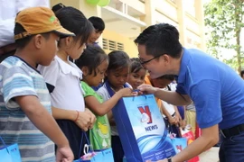 Trao quà Trung thu tặng các em nhỏ xóm Việt kiều “3 không”. (Ảnh: Thành Chung/Vietnam+)