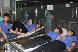 Các công nhân đang nằm cấp cứu tại phòng khám đa khoa Hoàn Hảo. (Ảnh: Huyền Trang/TTXVN)