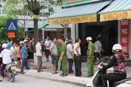 Lực lượng chức năng khám nghiệm hiện trường vụ thảm án. (Ảnh: Xuân Tiến/TTXVN)