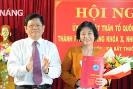 Phó Bí thư Thường trực Thành ủy Đà Nẵng Võ Công Trí trao quyết định và tặng hoa chúc mừng bà Đặng Thị Kim Liên. (Nguồn: danang.vn)