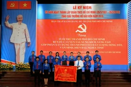Bí thư Thành ủy Đinh La Thăng tặng bức trướng cho Thành Đoàn thành phố. (Ảnh: An Hiếu/TTXVN)