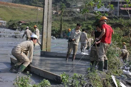 Công nhân nhà máy chì kẽm thu gom chất bùn thải đưa trả lại hồ chứa. (Ảnh: Quốc Đạt/TTXVN) 