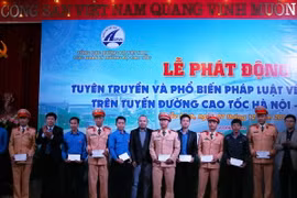 Tặng quà cho các thanh niên, cảnh sát giao thông có thành tích trong công tác đảm bảo trật tự an toàn giao thông. (Ảnh: Thái Hùng/TTXVN)