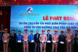 Tặng quà cho các thanh niên, cảnh sát giao thông có thành tích trong công tác đảm bảo trật tự an toàn giao thông. (Ảnh: Thái Hùng/TTXVN)
