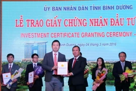 Ông Trần Văn Nam, Bí thư Tỉnh ủy Bình Dương trao giấy phép cho nhà đầu tư. (Ảnh: Quách Lắm/Vietnam+)